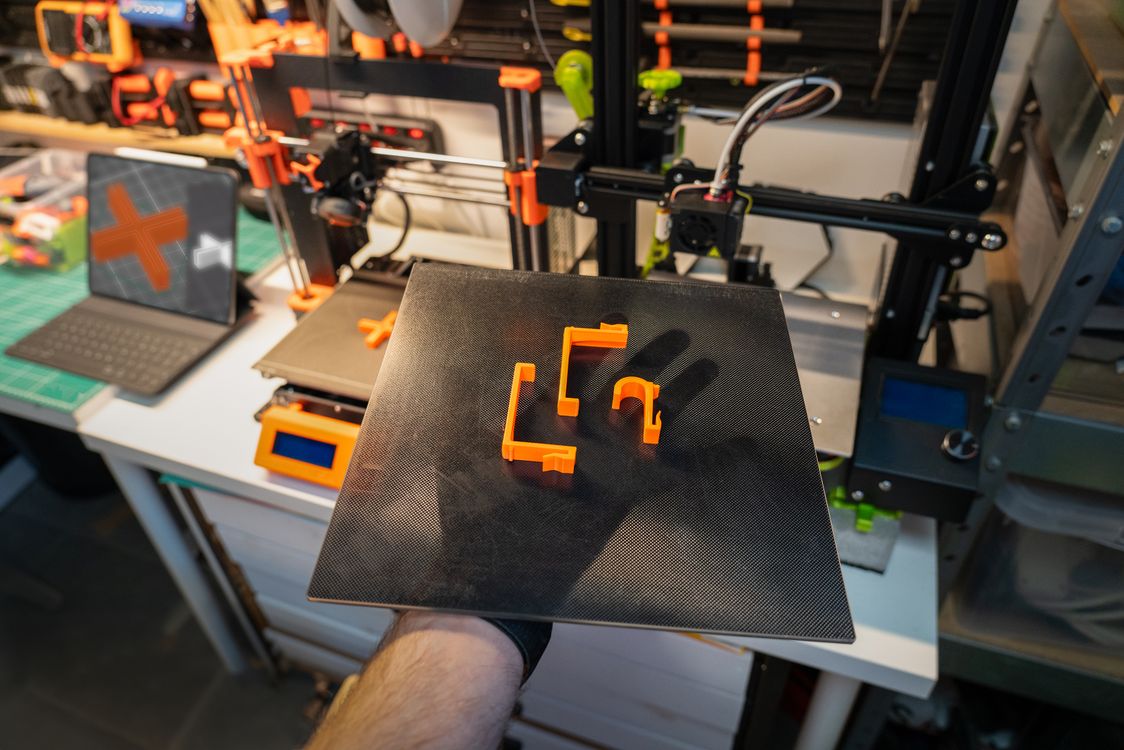 A tray of printed sample parts being removed from a 3D printer